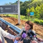 Deputada Bebel fiscaliza obras na SP-304 e cobra crédito ao BNDES, que fez o financiamento 10 18 06 26 A deputada Professora Bebel fala com a imprensa tendo as placas de divulgacao ao fundo